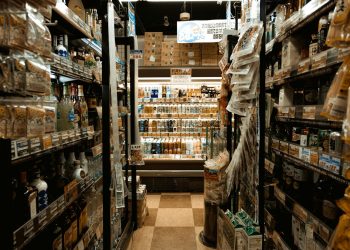 Explore a bustling Tokyo convenience store aisle packed with diverse products and merchandise.